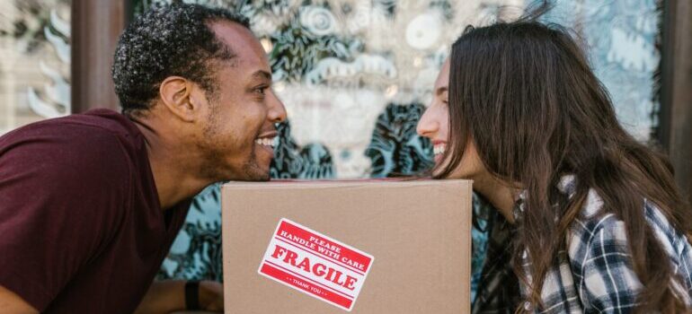 two people looking at each other, over a moving box