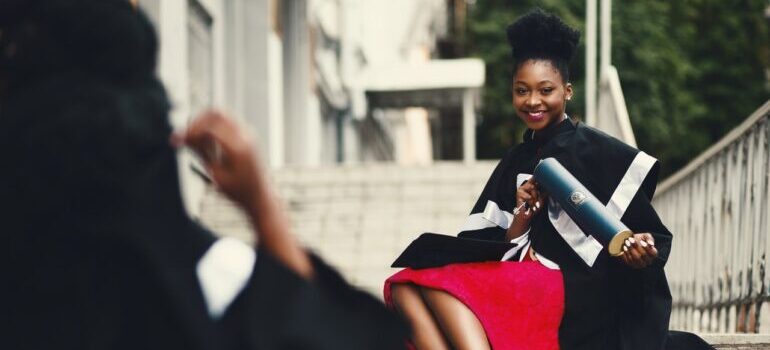 A young woman graduating from university after moving to Dallas.