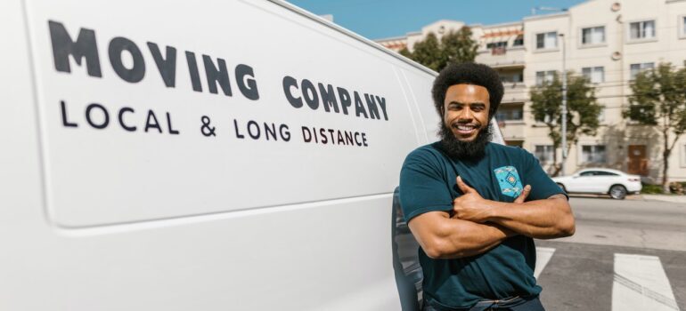 A mover standing next to a moving van.