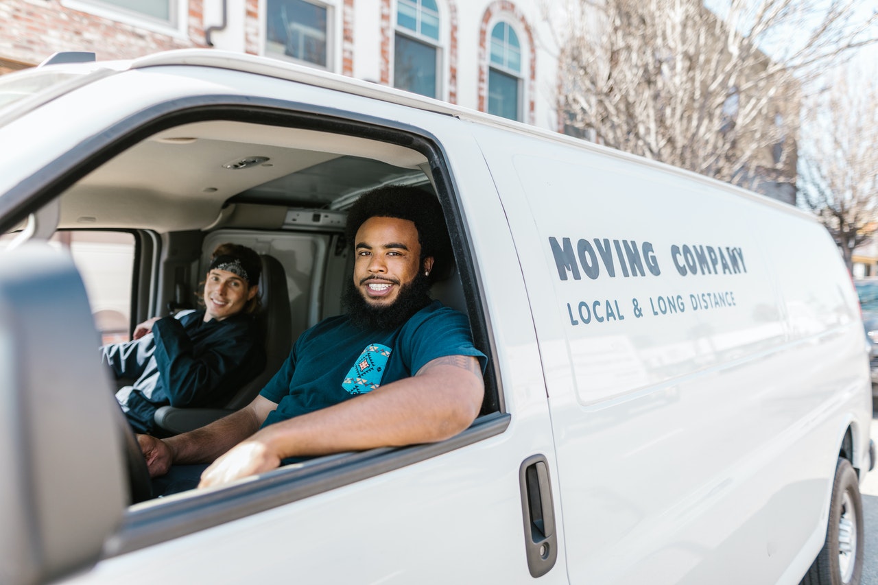 Two smiling movers in a moving van.
