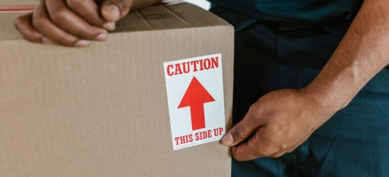 person carrying a box with a label on it