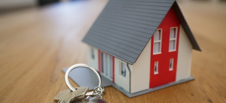 Keys next to a model of a house.