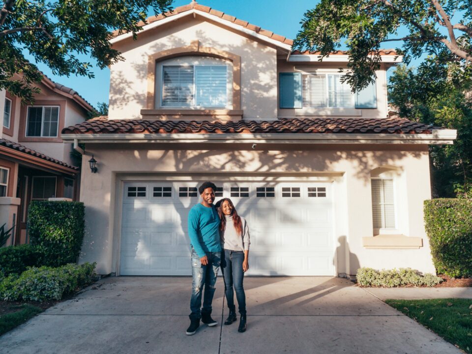 a couple in front of their house