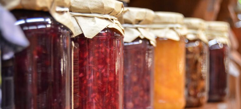 Jars of jam on a shelf.