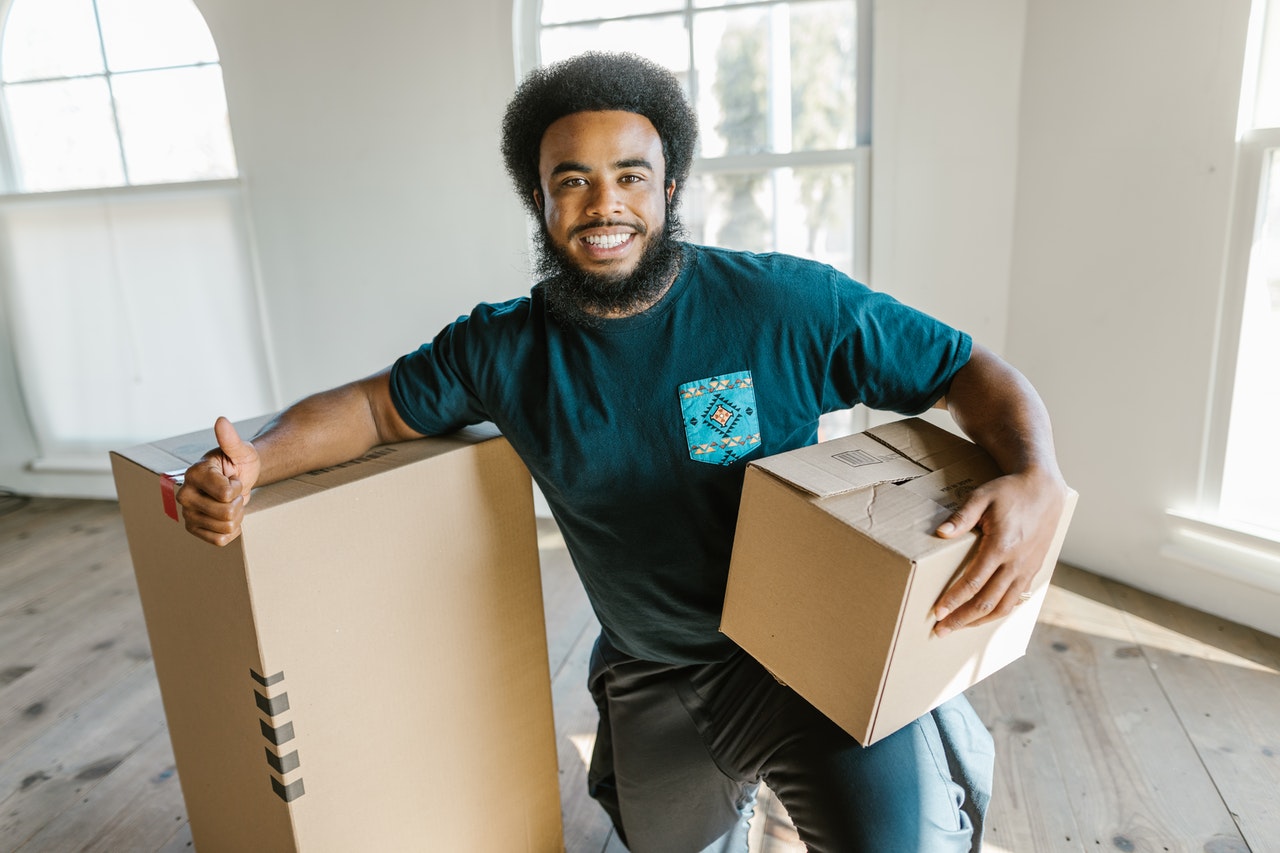 a mover holding a box and leaning onto another one