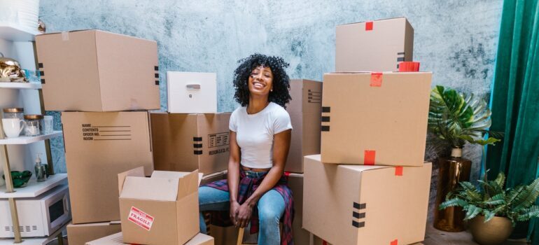 A woman surrounded by cardboard boxes, after moving from California to Texas.