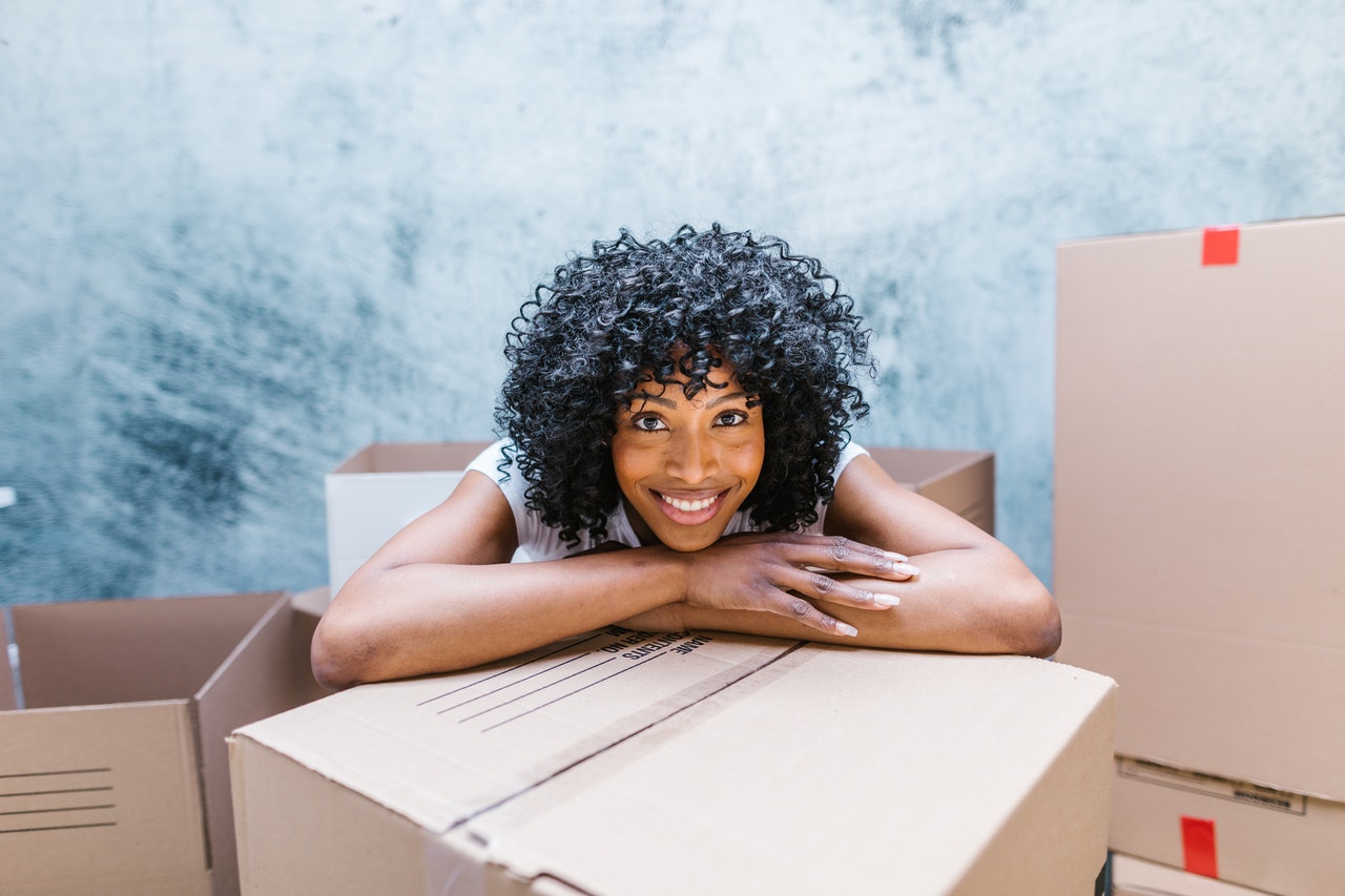 A woman leaning over a box, smiling