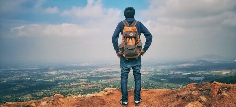 A man standing on a cliff after moving from California to Texas.