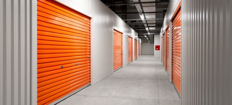 a storage unit interior with orange doors and gray walls