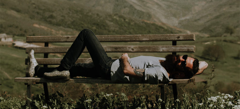 a man laying on the bench