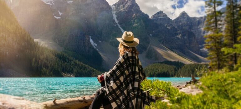 A woman sitting next to a lake