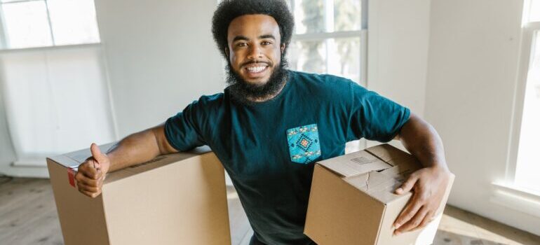 A member of Right Rate Movers posing for a photo with moving boxes around him