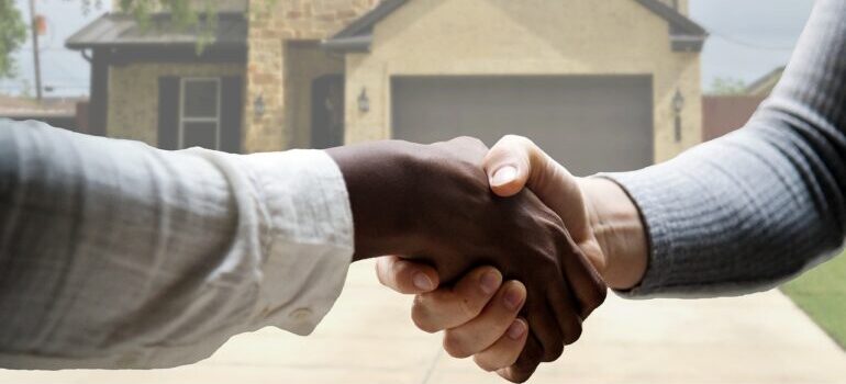 A handshake in front of a house.