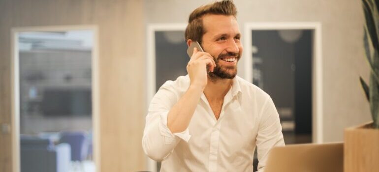 A man smiling while talking on the phone.