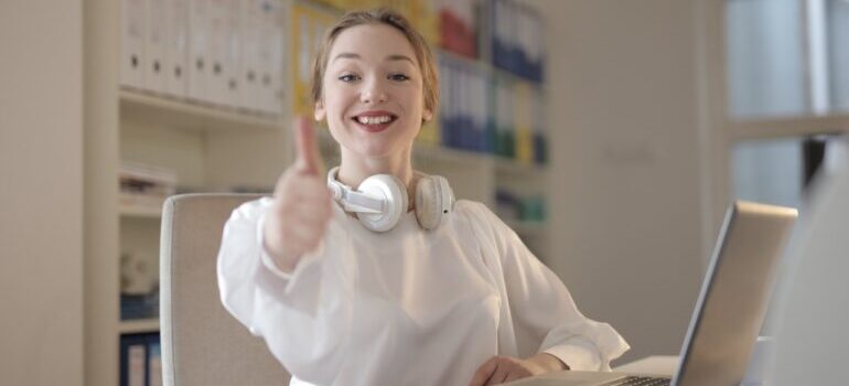 A woman holding up thumbs up.