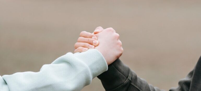two persons holding hands