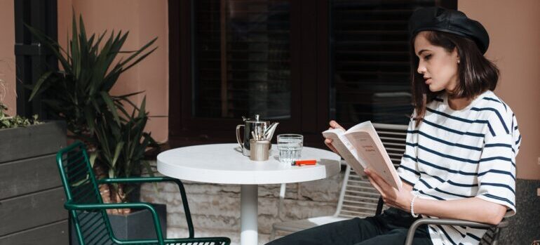 A woman reading a book at a caffe.