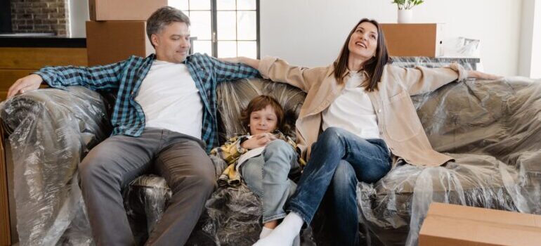 a family sitting on a wrapped couch