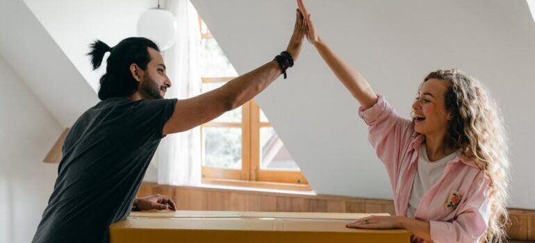 Couple high five to each other in a new apartment 