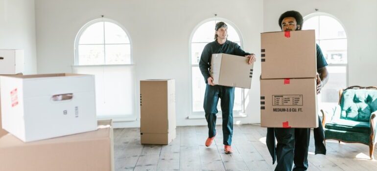 Two movers carrying boxes.