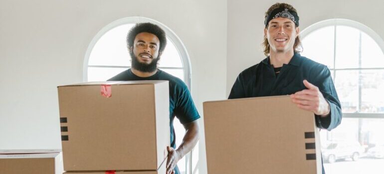 Two movers holding boxes.