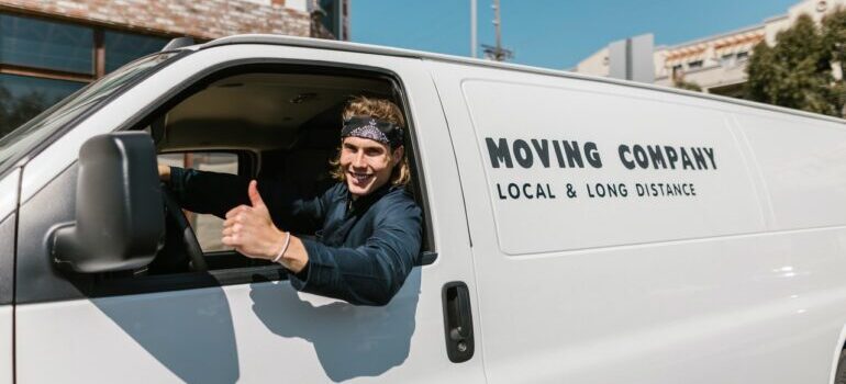 One of the top movers in San Jose posing in a movin van and smiling.