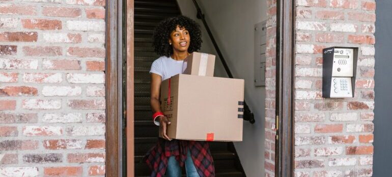 A woman carrying moving boxes.