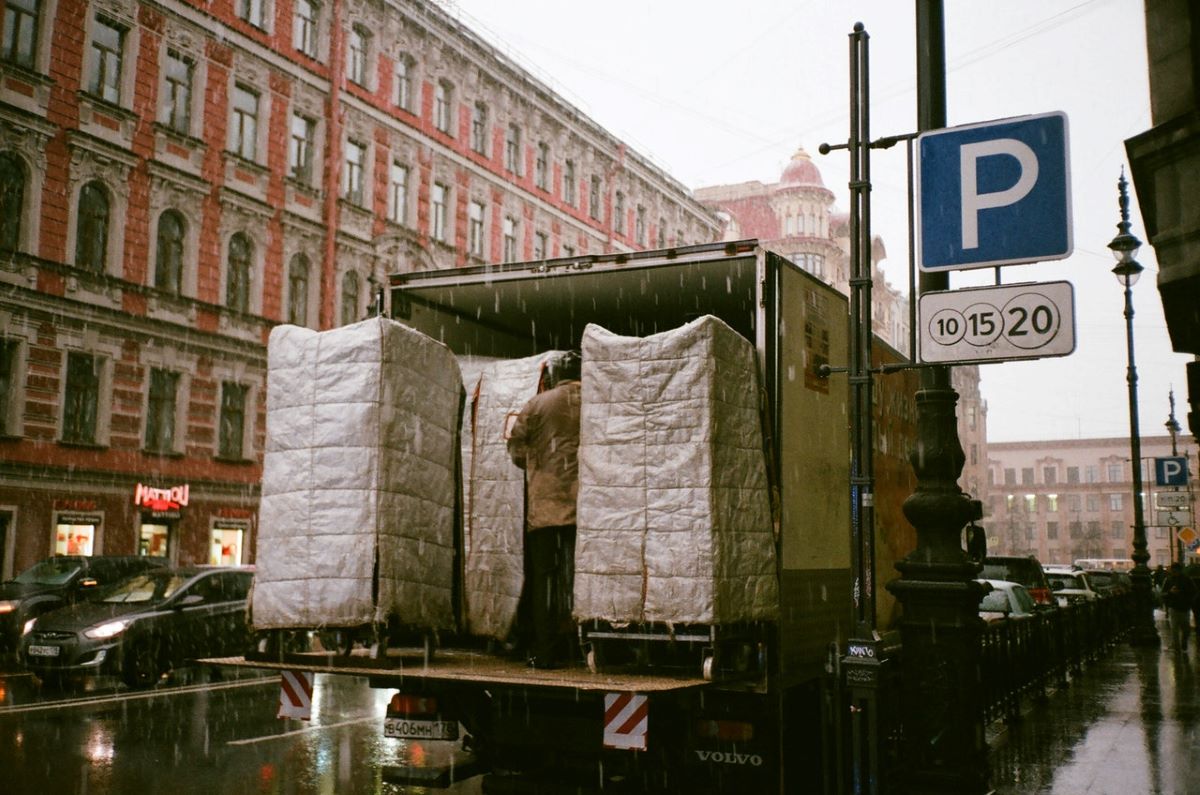 A moving truck being loaded on a rainy day.