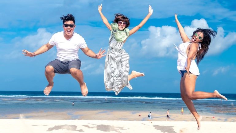 Three friends having fun at the beach in one of the best cities for job seekers in the U.S.