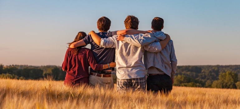 Four people in a group hug.