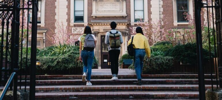 Three student walking into university campus.