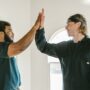 Two movers high-fiving after improving their performance due to following essential practice guidelines for moving companies.
