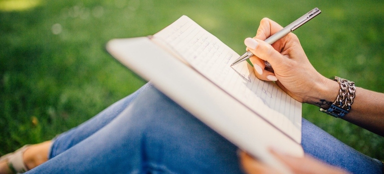 A woman writing something in a notebook.