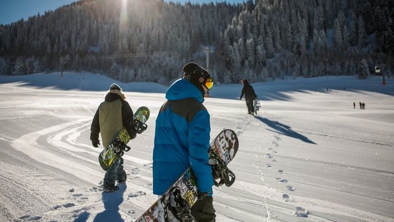 A group of snowboarders walking.