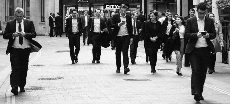 A black and white photo of business people on the street. 