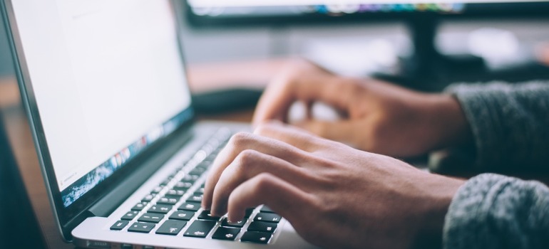 A man typing on a laptop.