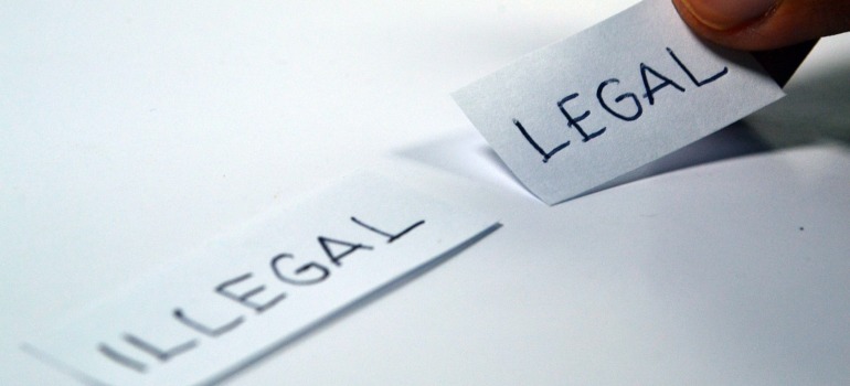 Two pieces of paper with the words legal and illegal written on them.