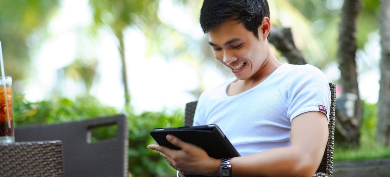 A man holding a tablet and searching for top movers in Fort Worth. 