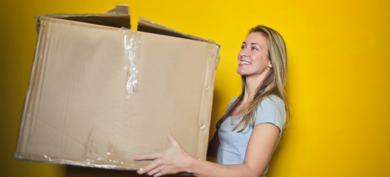 woman holding a box and smiling