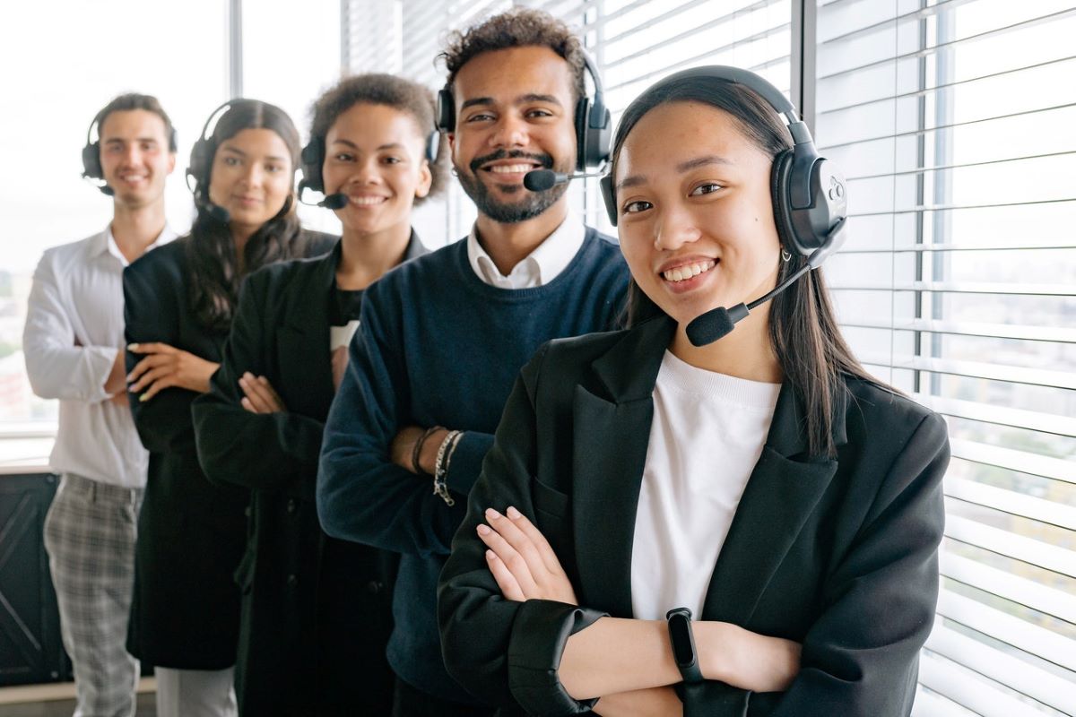 Customer support team smiling, showing Important qualities of good customer support