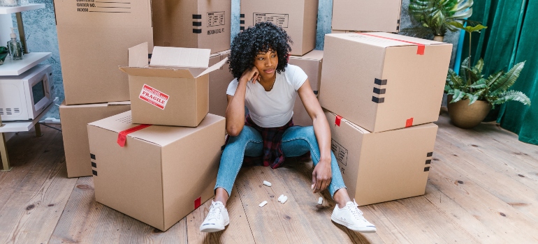beautiful black woman surrounded by cardboard boxes
