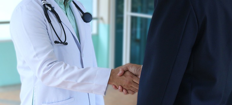 A doctor and a patient shaking hands.