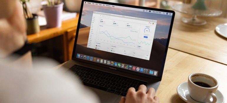 A man looking at charts on a laptop.