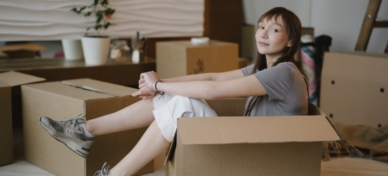 A girl sitting in moving box