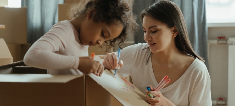Mother and daughter painting a box