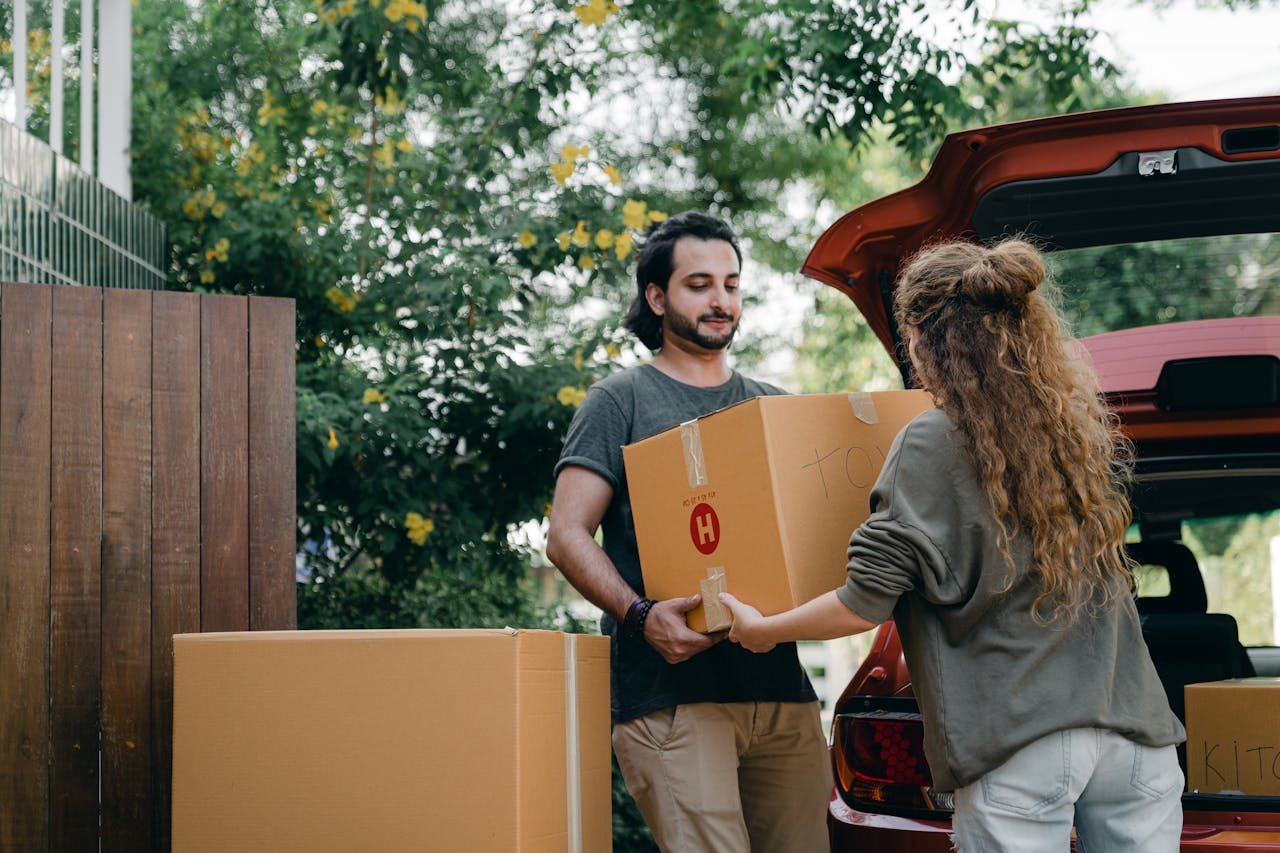 man and woman carrying boxes