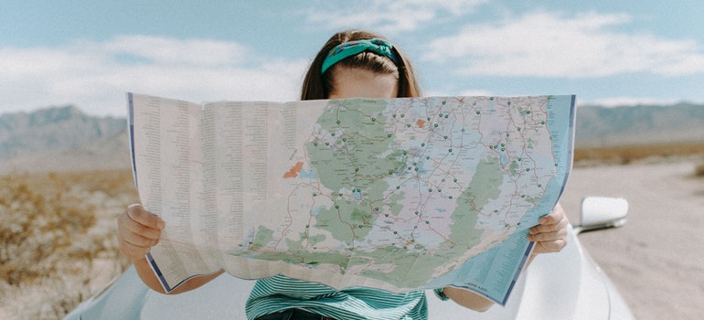 a girl holding a map of places to visit after moving from Colorado to New York