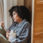 A woman looking sad through window as a symbol of how to cope if you regret moving