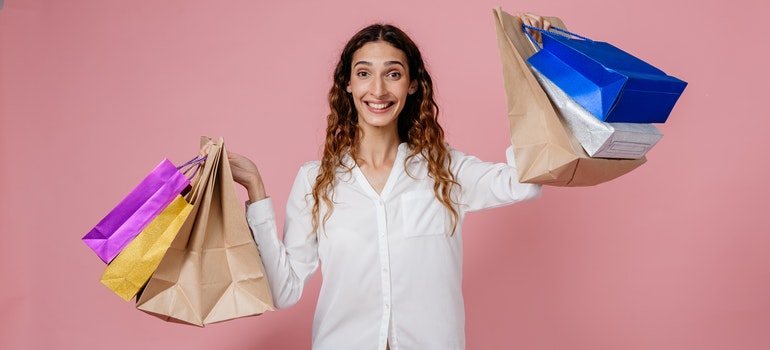 a woman holding shopping bags and smiling.