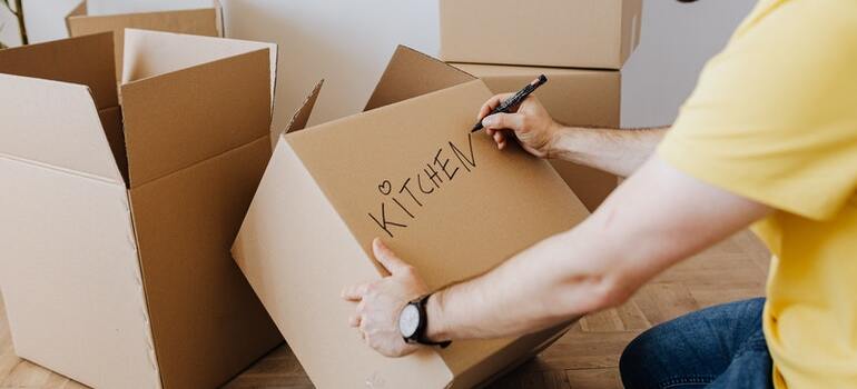 A person labeling a movign box